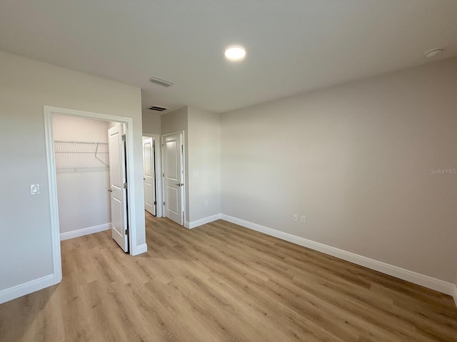 17099 Carleen Ave, Port Charlotte, FL 33948 - unfurnished bedroom featuring light wood-style flooring, baseboards, a spacious closet, and a closet