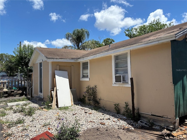 4213 W Cayuga St, Tampa, FL 33614 - view of home's exterior with cooling unit, stucco siding, and roof with shingles