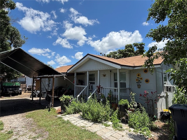 4213 W Cayuga St, Tampa, FL 33614 - view of front of home with a detached carport, covered porch, and a shingled roof
