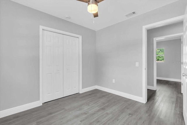 2711 E 22nd Ave, Tampa, FL 33605 - unfurnished bedroom with wood finished floors, baseboards, a closet, and a ceiling fan