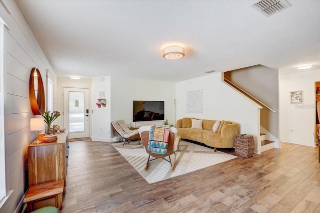 11121 Running Pine Dr, Riverview, FL 33569 - living room featuring wood finished floors, stairs, baseboards, and a textured ceiling