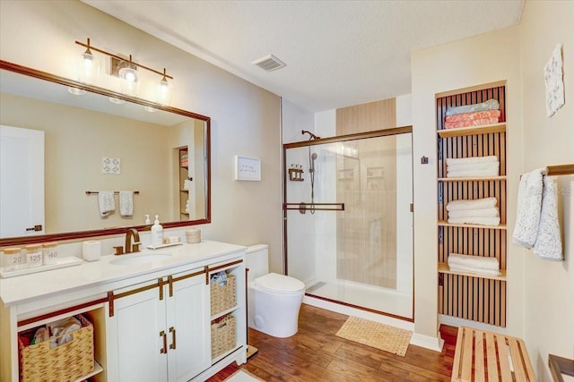 11121 Running Pine Dr, Riverview, FL 33569 - full bathroom with a stall shower, vanity, toilet, wood finished floors, and a textured ceiling