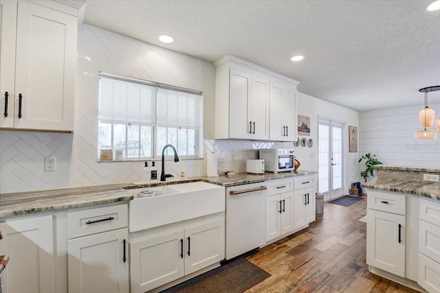 11121 Running Pine Dr, Riverview, FL 33569 - kitchen featuring dishwasher, a sink, a textured ceiling, tasteful backsplash, and french doors