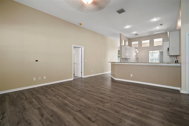 unfurnished living room featuring dark wood-style flooring, ceiling fan, baseboards, and recessed lighting