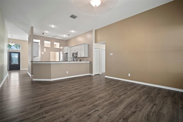 kitchen featuring dark wood-type flooring, open floor plan, baseboards, stainless steel appliances, and recessed lighting