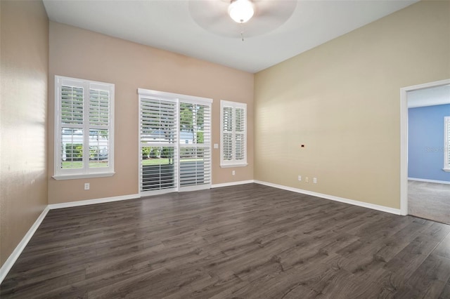 unfurnished room featuring ceiling fan, dark wood-style flooring, and baseboards