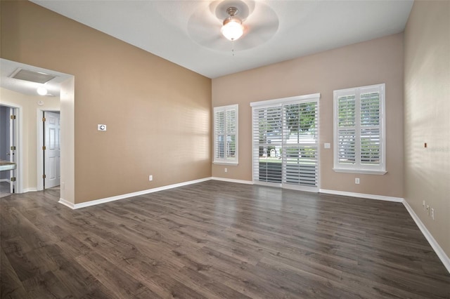 spare room with ceiling fan, dark wood-style floors, and baseboards
