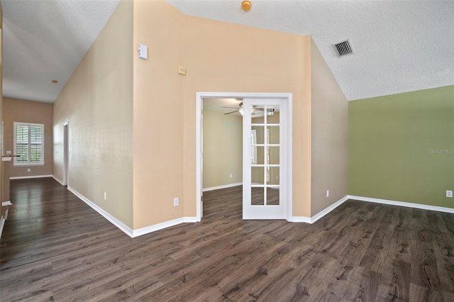 unfurnished room with lofted ceiling, dark wood-type flooring, baseboards, a ceiling fan, and a textured ceiling