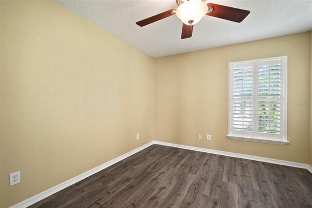 unfurnished room with dark wood-type flooring, baseboards, a ceiling fan, and a textured ceiling
