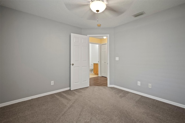 empty room with carpet floors, ceiling fan, baseboards, and a textured ceiling