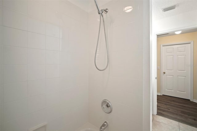 bathroom featuring bathtub / shower combination and wood finished floors