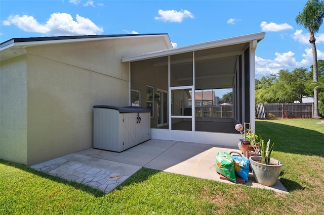back of house featuring a sunroom, stucco siding, and a patio area