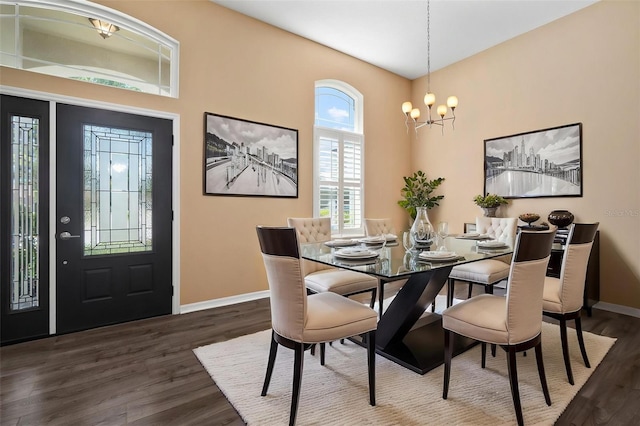 dining area featuring a chandelier, dark wood finished floors, and baseboards