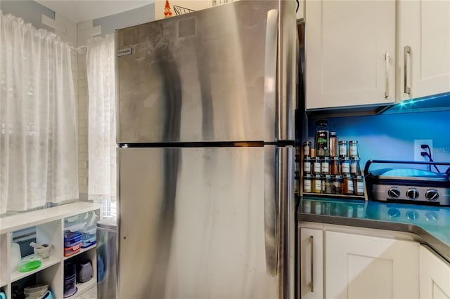 2721 Baird Ct, Palm Harbor, FL 34684 - kitchen featuring freestanding refrigerator, white cabinets, and dark countertops