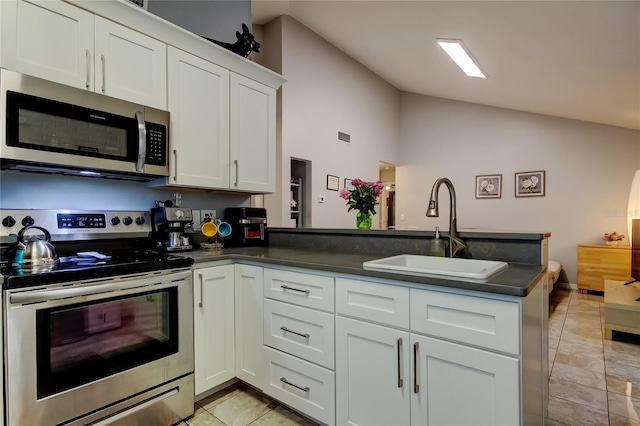 2721 Baird Ct, Palm Harbor, FL 34684 - kitchen featuring appliances with stainless steel finishes, a sink, dark countertops, a peninsula, and white cabinetry