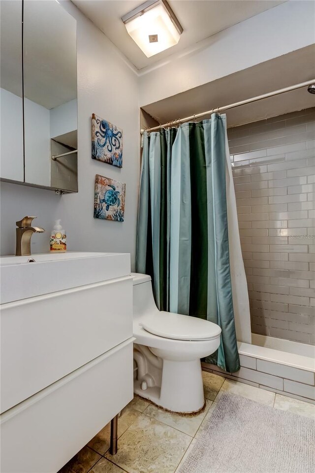 2721 Baird Ct, Palm Harbor, FL 34684 - bathroom featuring tiled shower, toilet, tile patterned flooring, and vanity