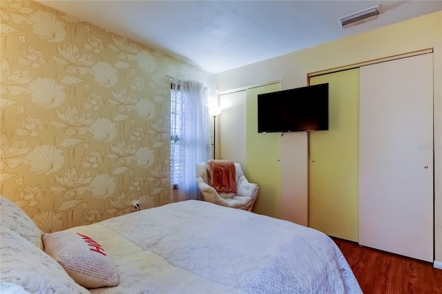 2721 Baird Ct, Palm Harbor, FL 34684 - bedroom with wallpapered walls, multiple closets, and wood finished floors