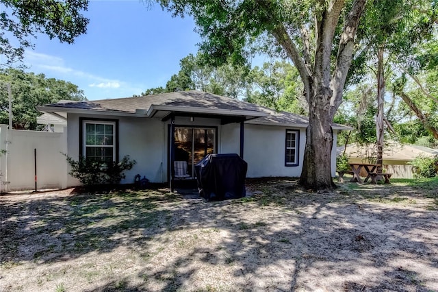 2721 Baird Ct, Palm Harbor, FL 34684 - back of property with stucco siding, fence, and a shingled roof