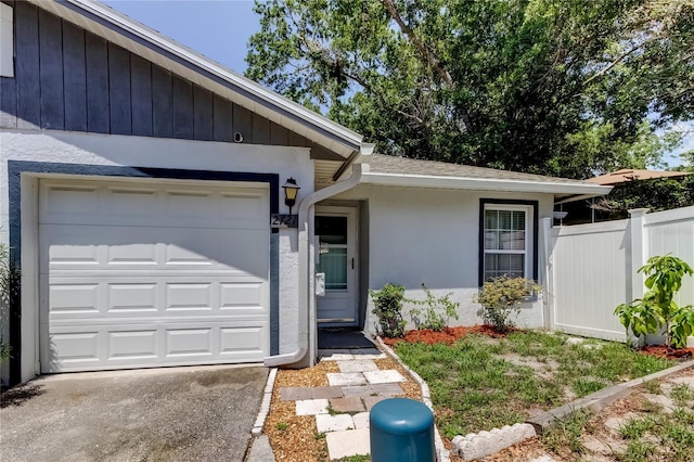 2721 Baird Ct, Palm Harbor, FL 34684 - entrance to property featuring fence, stucco siding, driveway, a shingled roof, and a garage