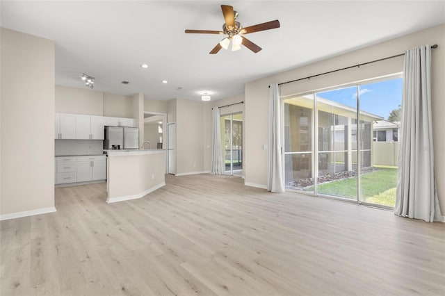 3023 Minuteman Ln, Brandon, FL 33511 - unfurnished living room featuring light wood finished floors, a ceiling fan, healthy amount of natural light, baseboards, and recessed lighting