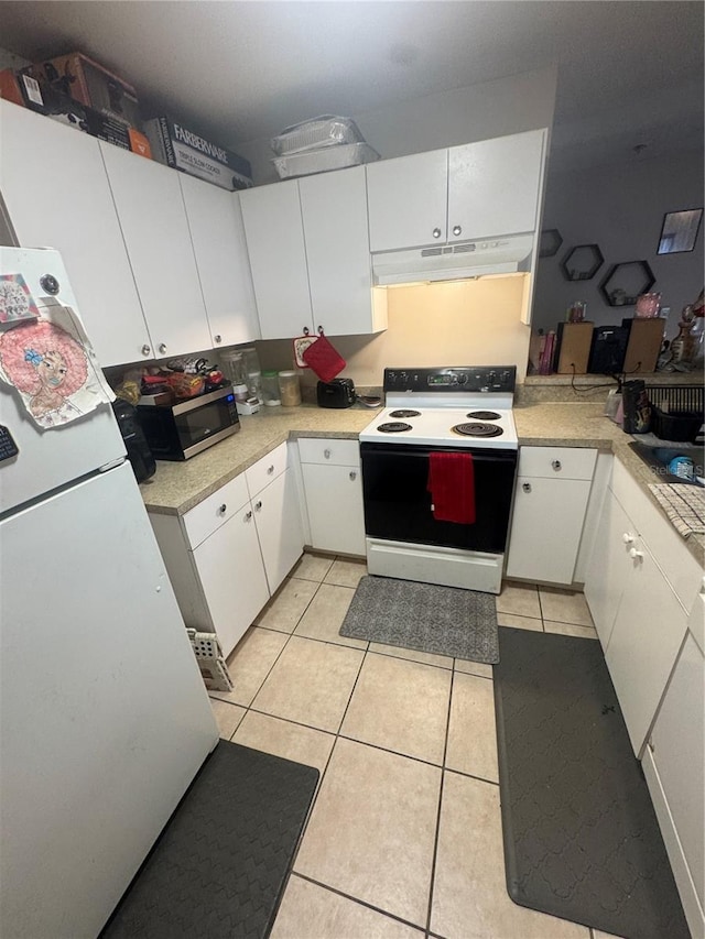 3710 N 57th St, Tampa, FL 33619 - kitchen with electric stove, under cabinet range hood, stainless steel microwave, light tile patterned floors, and light countertops