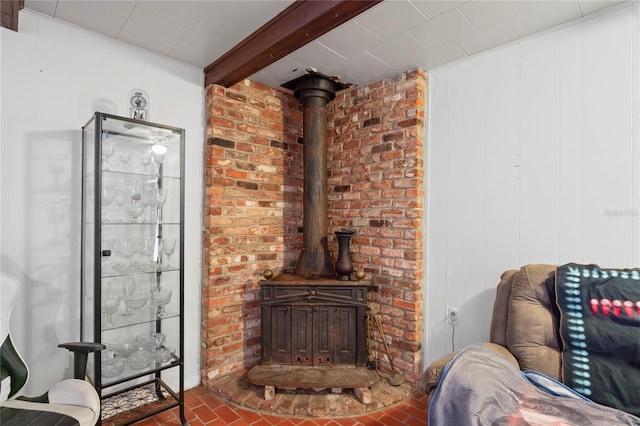 8828 Jasmine Blvd, Port Richey, FL 34668 - living area with a wood stove, brick patterned floors, and beam ceiling