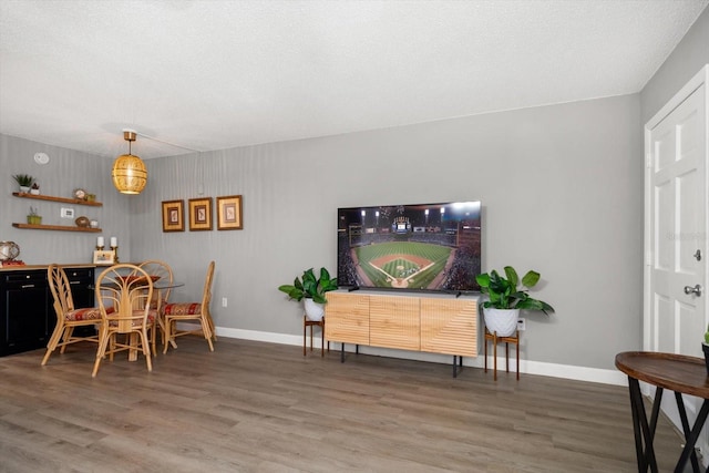 dining space with light wood finished floors, baseboards, and a textured ceiling