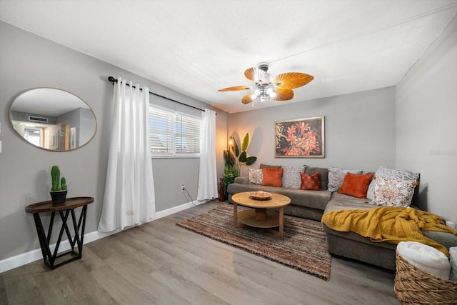 living room with ceiling fan, wood finished floors, and baseboards