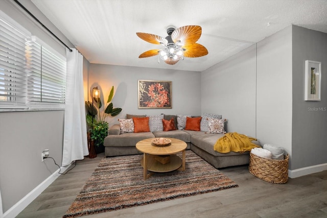 living room with wood finished floors, baseboards, and a ceiling fan