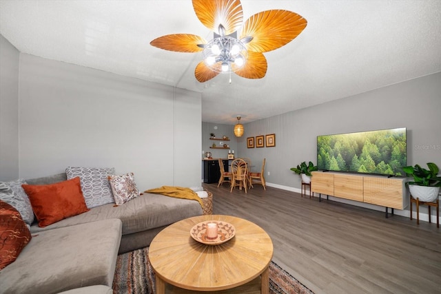 living room with wood finished floors, ceiling fan, and baseboards