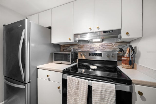 kitchen with under cabinet range hood, appliances with stainless steel finishes, decorative backsplash, and white cabinets