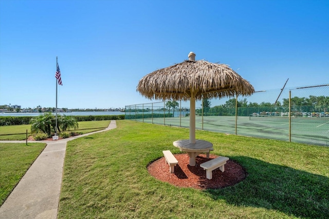 view of community with a tennis court and a water view