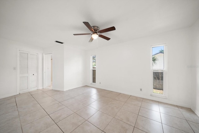 1142 Lancer Ln, Tarpon Springs, FL 34689 - unfurnished room with plenty of natural light, a ceiling fan, and light tile patterned floors