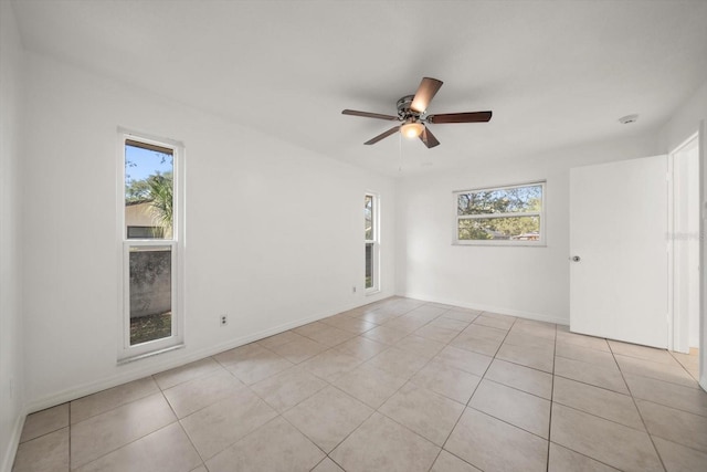 1142 Lancer Ln, Tarpon Springs, FL 34689 - empty room featuring plenty of natural light, a ceiling fan, light tile patterned flooring, and baseboards