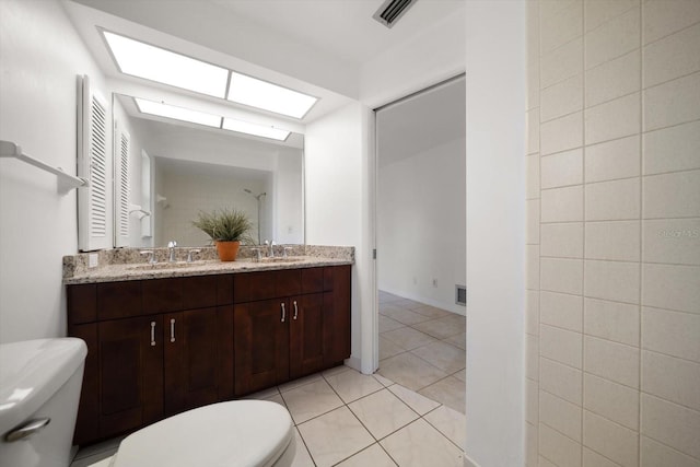 1142 Lancer Ln, Tarpon Springs, FL 34689 - full bathroom featuring toilet, double vanity, a skylight, and tile patterned flooring