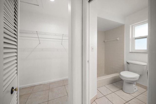 1142 Lancer Ln, Tarpon Springs, FL 34689 - bathroom featuring toilet, tile patterned flooring, tiled shower, baseboards, and a spacious closet