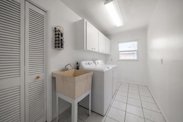 1142 Lancer Ln, Tarpon Springs, FL 34689 - washroom with cabinet space, separate washer and dryer, baseboards, and light tile patterned flooring