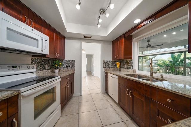 1142 Lancer Ln, Tarpon Springs, FL 34689 - kitchen with white appliances, a sink, a tray ceiling, tasteful backsplash, and light tile patterned flooring