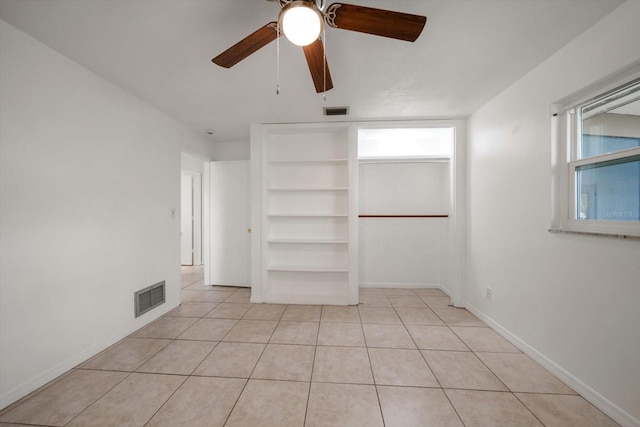 1142 Lancer Ln, Tarpon Springs, FL 34689 - unfurnished bedroom with light tile patterned flooring, a ceiling fan, baseboards, and a closet