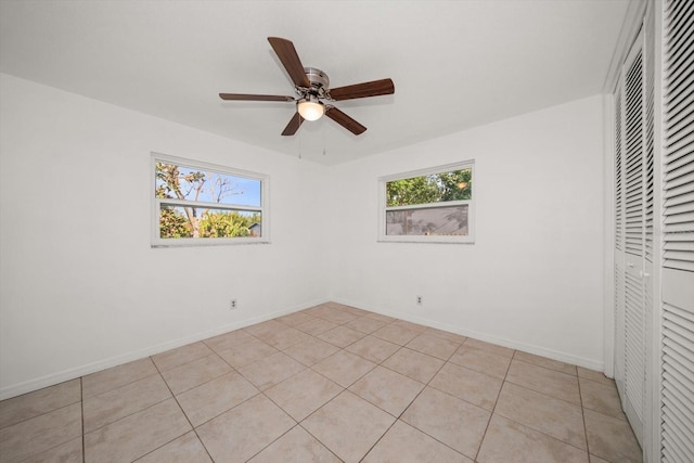 1142 Lancer Ln, Tarpon Springs, FL 34689 - unfurnished bedroom featuring light tile patterned floors, a closet, baseboards, and ceiling fan