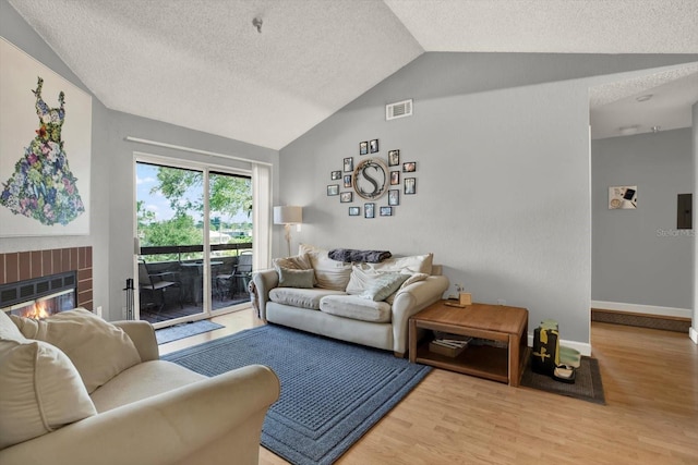 10265 Gandy Blvd N Unit 906, Saint Petersburg, FL 33702 - living room featuring lofted ceiling, wood finished floors, a textured ceiling, a fireplace, and baseboards