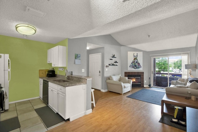 10265 Gandy Blvd N Unit 906, Saint Petersburg, FL 33702 - kitchen with open floor plan, dishwashing machine, white cabinets, vaulted ceiling, and a textured ceiling