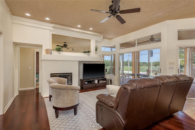 800 Belted Kingfisher Dr S, Palm Harbor, FL 34683 - living room with a ceiling fan, a large fireplace, a textured ceiling, recessed lighting, and wood finished floors