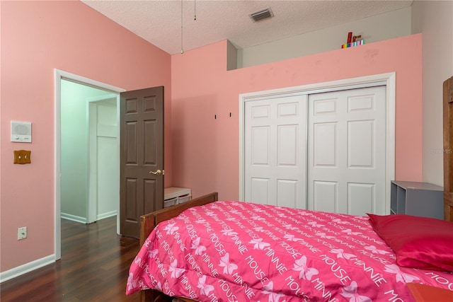 800 Belted Kingfisher Dr S, Palm Harbor, FL 34683 - bedroom featuring dark wood-type flooring, a textured ceiling, a closet, and baseboards