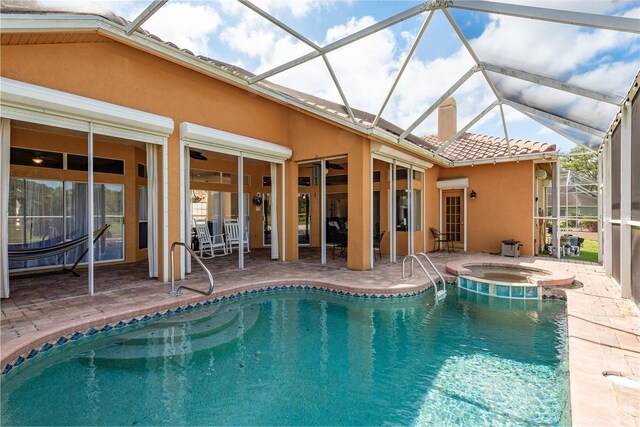 800 Belted Kingfisher Dr S, Palm Harbor, FL 34683 - view of swimming pool featuring a patio, a ceiling fan, glass enclosure, and a pool with connected hot tub