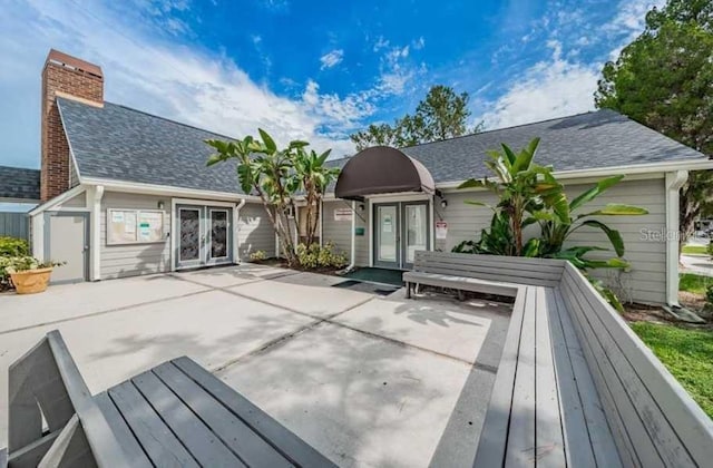 1400 Gandy Blvd N Unit 1705, Saint Petersburg, FL 33702 - back of property featuring french doors, a chimney, and roof with shingles