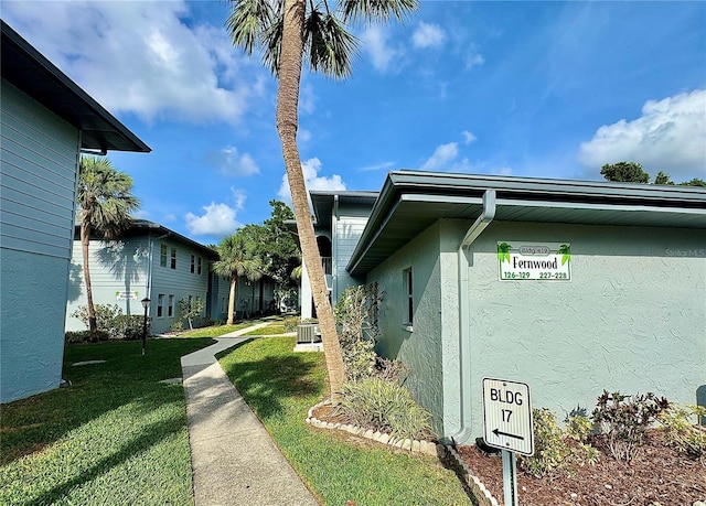 10800 US Highway 19 N Unit 127, Pinellas Park, FL 33782 - view of side of home featuring stucco siding, a lawn, and central air condition unit