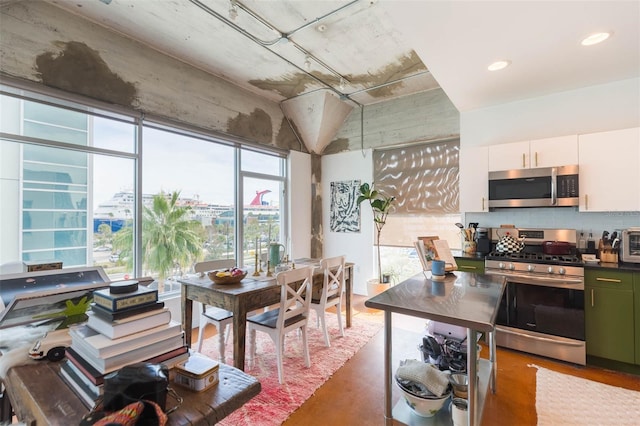 101 N 12th St Unit 400, Tampa, FL 33602 - kitchen featuring appliances with stainless steel finishes, decorative backsplash, white cabinetry, dark countertops, and recessed lighting