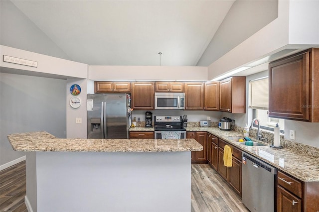 6118 Becklin Pl, Riverview, FL 33578 - kitchen featuring stainless steel appliances, a sink, light wood-type flooring, a kitchen island, and light stone countertops