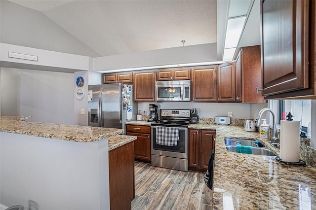 6118 Becklin Pl, Riverview, FL 33578 - kitchen with stainless steel appliances, a sink, light wood-type flooring, lofted ceiling, and light stone countertops